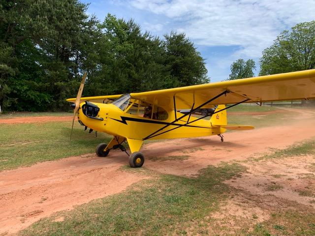 Yellow light aircraft on a country airfield