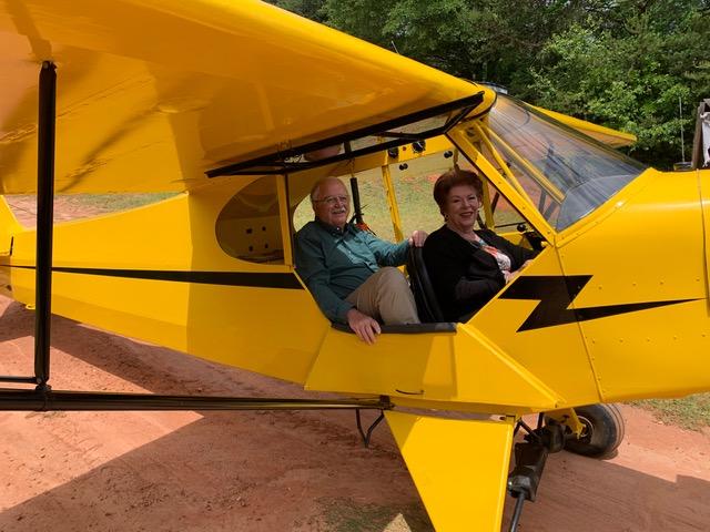 D.A. Francis and his wife seated in a yellow light aircraft