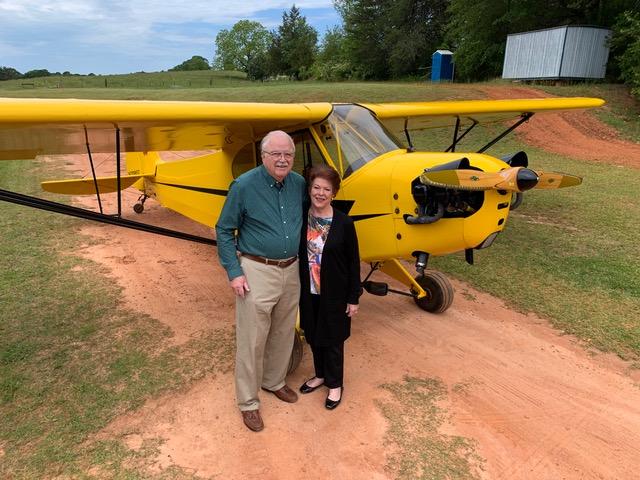D.A. Francis and his wife standing beside a yellow light aircraft